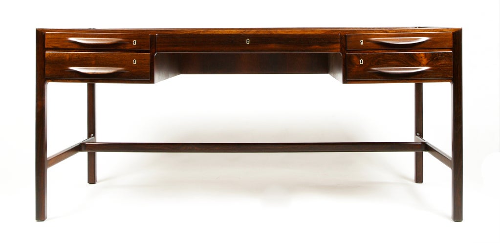Exceptional quality crafted Rosewood desk with 5 drawers by Kurt Østervig with delicate one-piece (Rosewood front) shaped handles and solid oak structure.