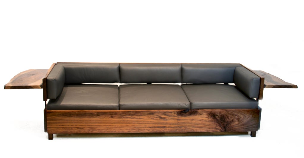 A very substantial and heavy sofa by Thomas Hayes Studio which has been expertly hand crafted with 2 inch thick live edge slabs of Walnut. The cushions have been upholstered with a dark gray leather. The brackets are solid 3/8