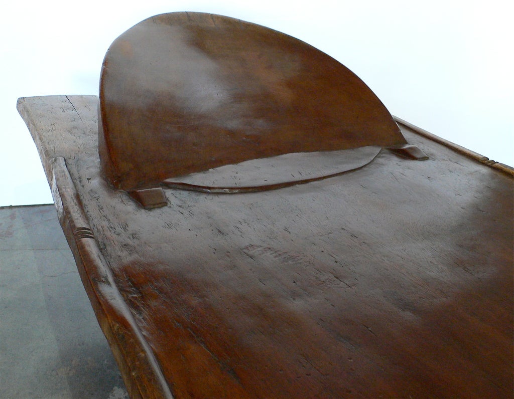 Large and hard-to-come-by Senufo bed. Hand hewn from a single iroko wood log. Used for ceremonies and for sleeping. The Senufo
in the Kufulo region of Cote d'Ivoire call these kpaala. Raised headrest, incised notches in groups of threes extending