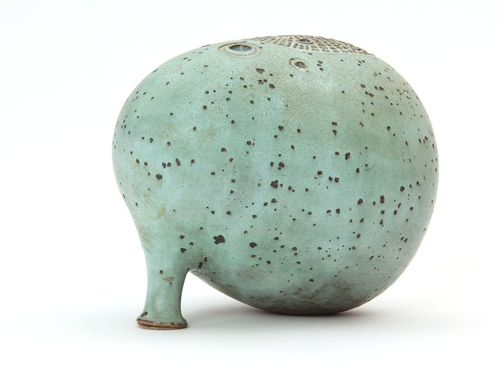 An open ceramic sculpture which can be displayed vertically or horizontally (resting on footed protrusion). Repeating circular hole motif interplays with mosaic etching.

Finished in a sea-foam green matte glaze.