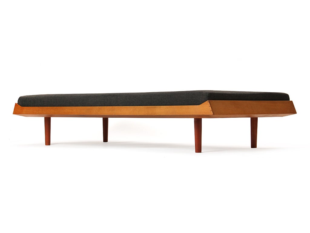 A simple oak Danish daybed with tapered teak dowel legs.