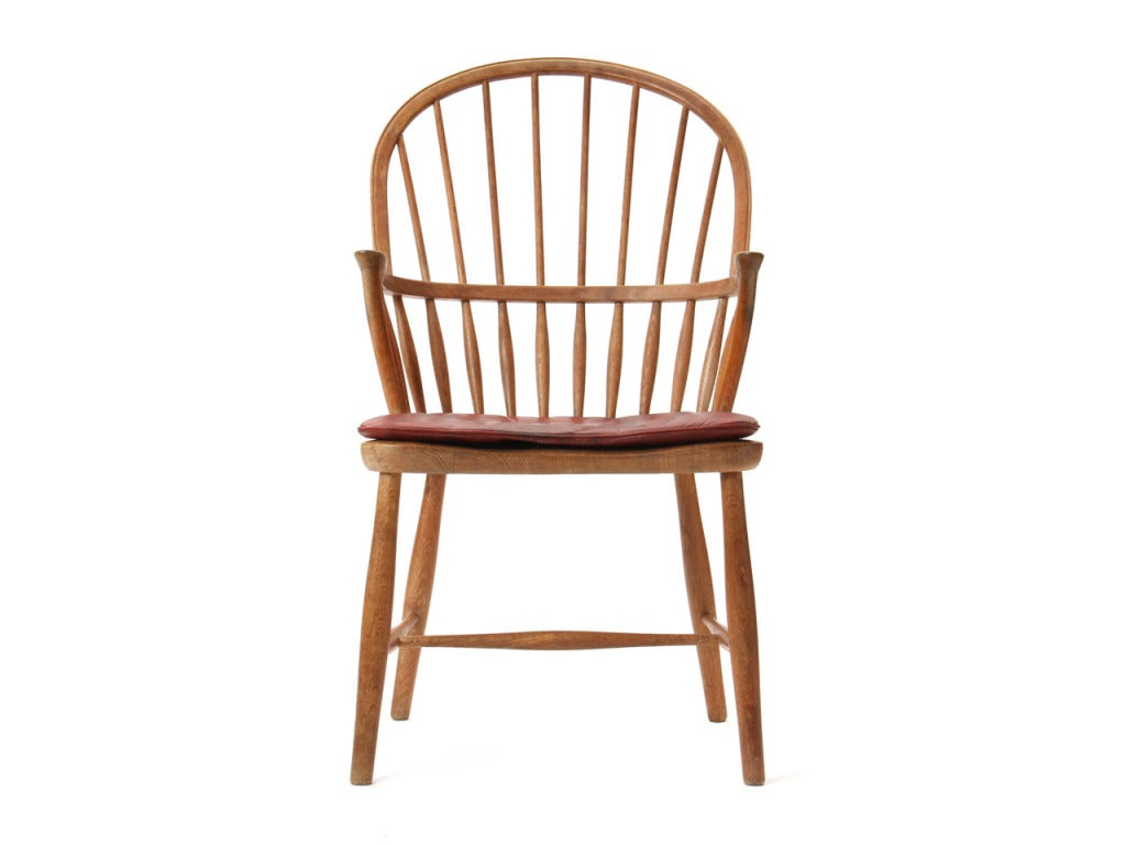Une chaise Windsor en chêne avec la garniture d'assise originale en cuir rouge de chèvre nigérien.
