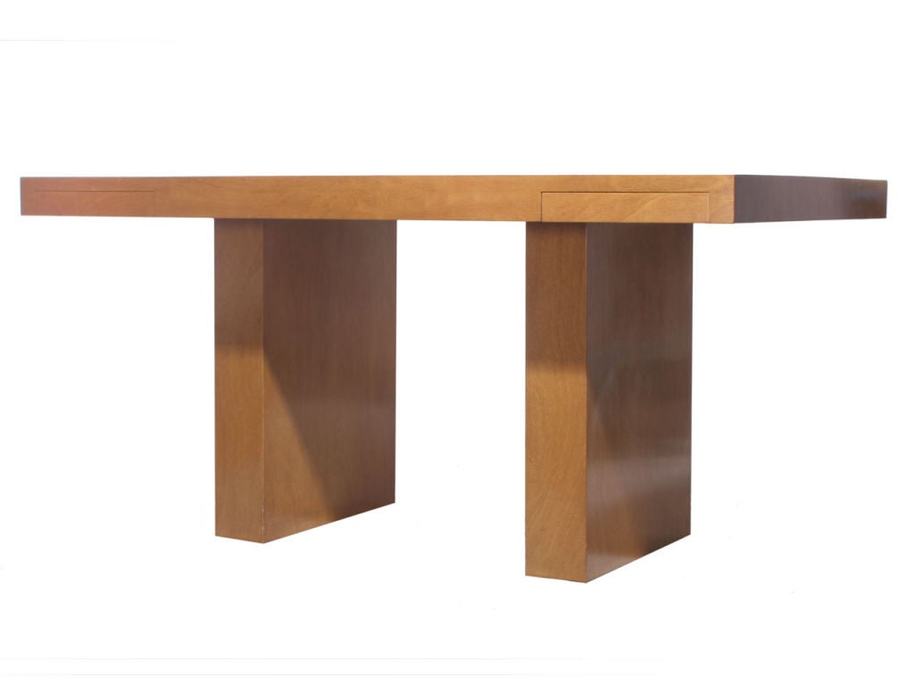 A simple and elegant walnut desk designed by Edward Wornley. The desk features a floating thick-planked top with two drawers supported by parallel slab legs. Made by Dunbar in the USA, circa 1950s.