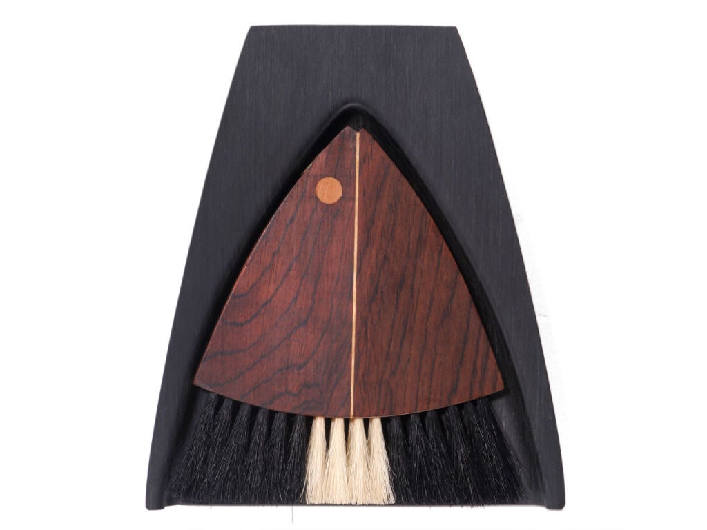 A dustpan with a rosewood brush with inlays resembling a fish.