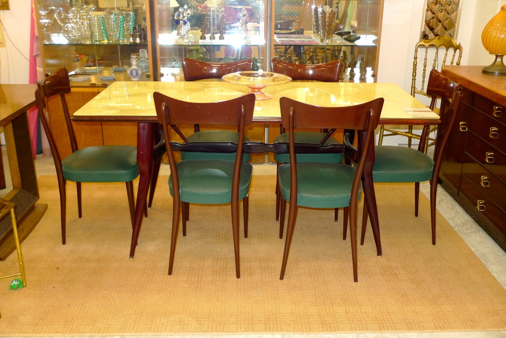 1950's Italian Rosewood Dining Table by Vittorio Dassi. The top is a single piece of glass which has the original reverse-paint marbelized finish the colors of creme brule. 



At present we also have the matching long sideboard, also with the