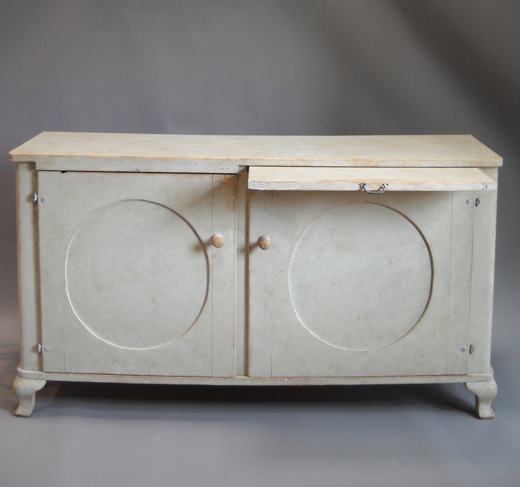 Swedish sideboard, circa 1800, from Ångermanland. Long and narrow with simple paneled doors and pull-out serving board. Open interior with one shelf.