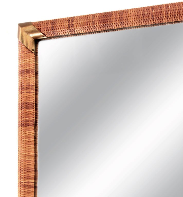 Wall-hanging mirror with cane wrapped frame and brass accents by T.H. Robsjohn-Gibbings for Widdicomb, American, 1950s.