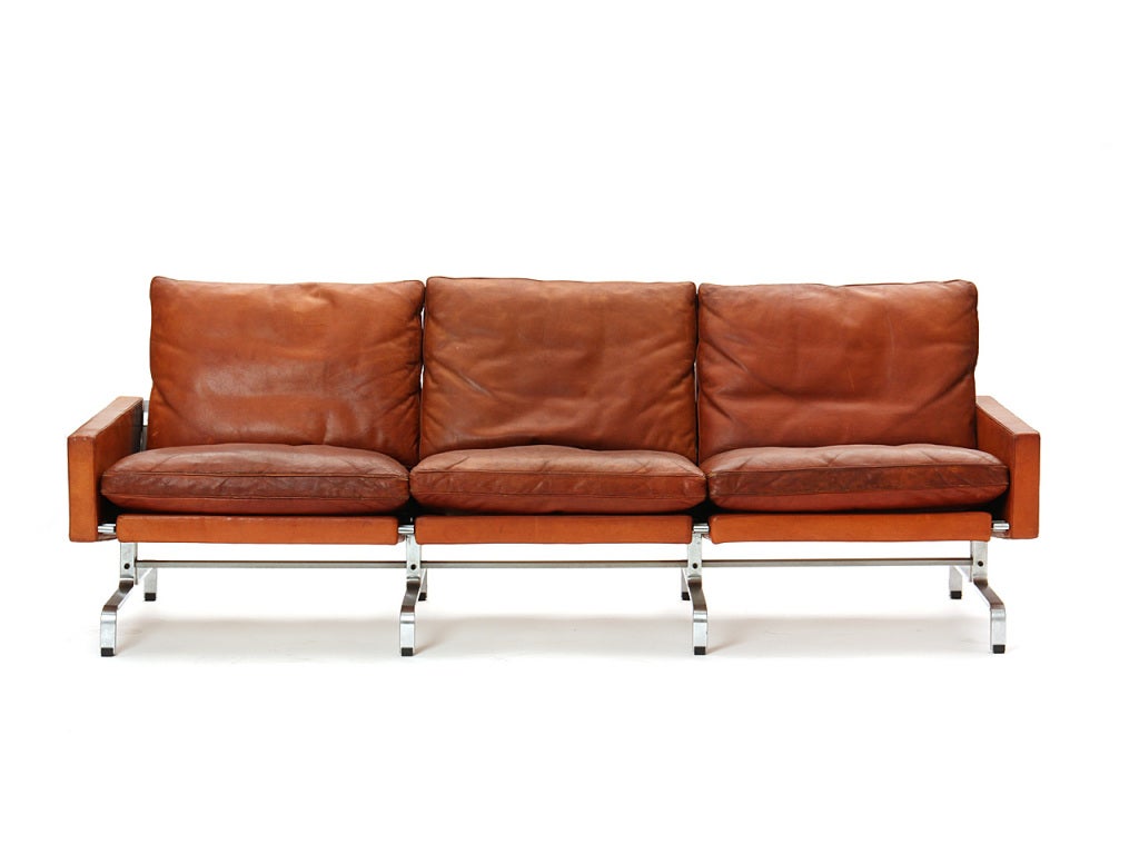 A three-seat sofa with a stainless steel frame and the original brown leather upholstery. Manufactured by E. Kold Christensen.