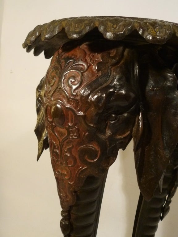 Pair Continental Cast Bronze Elephant Motif Tripod Base Lamp Tables. The stylised elephant heads and elongated trunks forming the legs which support the guilloche bordered tops.