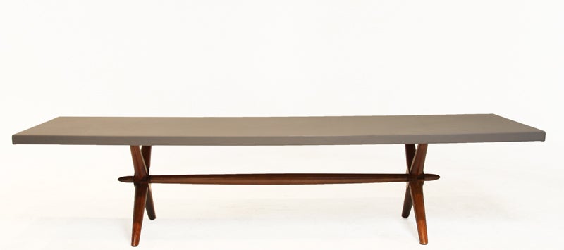 Mahogany coffee table with X-base designed by T.H. Robsjohn-Gibbings for Widdicomb with a gray leather tabletop.

 