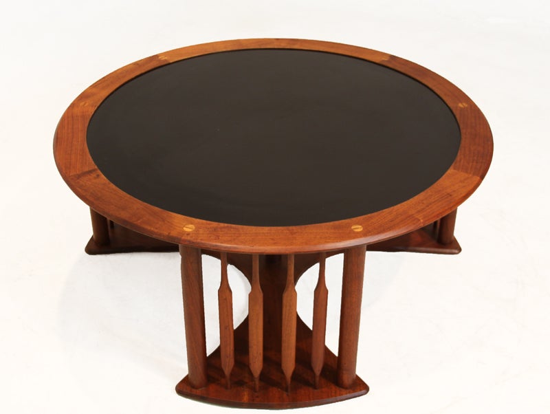 Round coffee table with solid walnut base and knife edge details by Kipp Stewart. This California Craftsman table has 6 beautifully crafted joints as seen in photos. Walnut banding frames the black Formica table top surface.  This table retains the