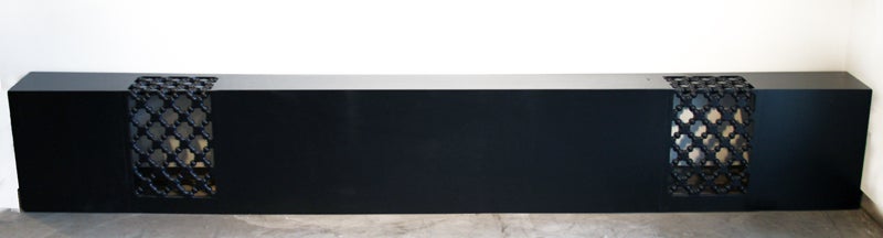 Large black lacquered Walnut piece that could be used as king size headboard or as an low console or entrance table. The large piece of black lacquered Walnut is broken up with two sections of carved trellising. Measurements between trellIs reliefs