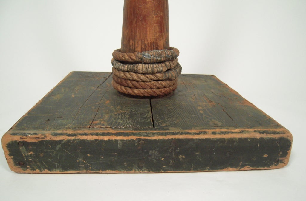 A 19th century American fid. A fid is a conical tool made of wood or bone. It is used to work with rope and canvas in marlinespike seamanship. A fid is used to hold open knots and holes in canvas. This example is accompanied by 5 rope rings for a