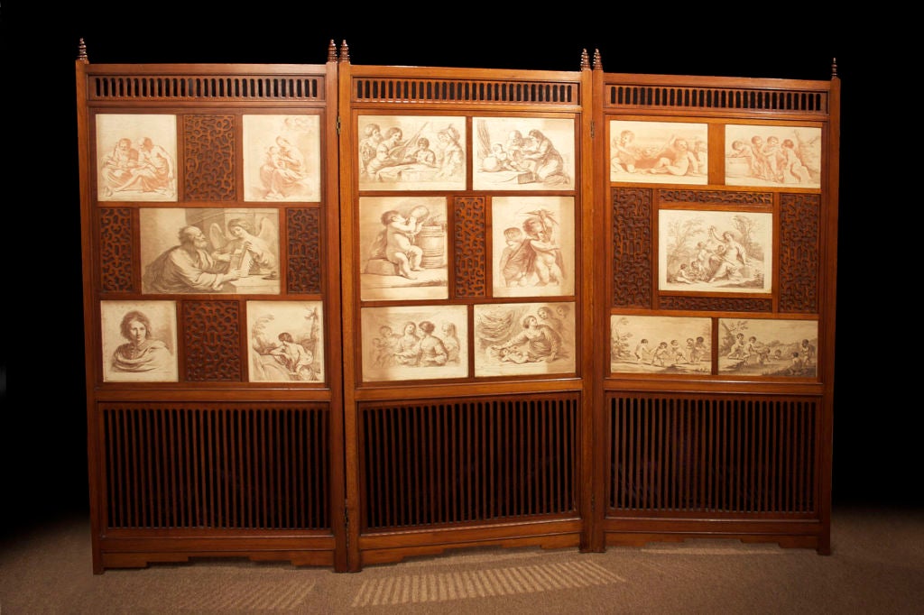 # M015 -A very decorative late Victorian mahogany three fold screen incorporating a series of prints. Each panel with a pierced arcaded frieze and pointed finials above a grouping of prints and blind fret panels with an unusual amorphic design. The