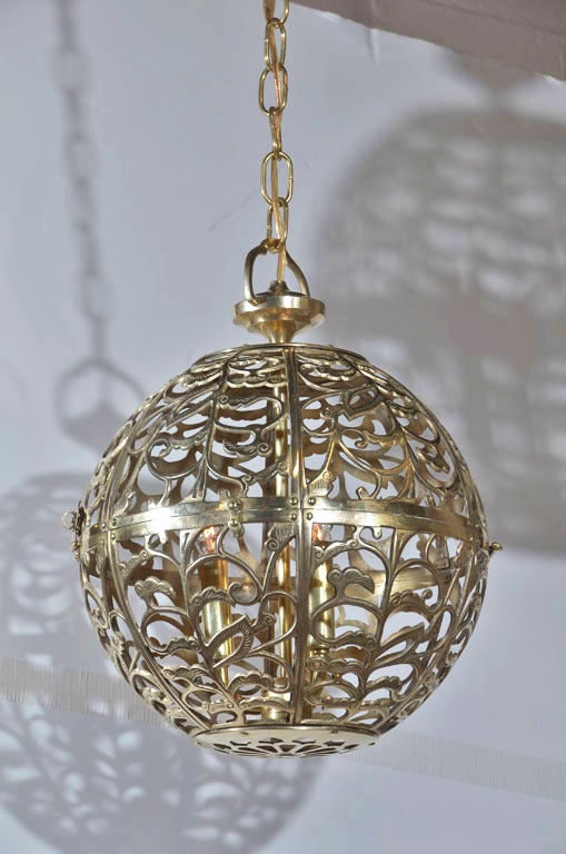 Pair of Asian pierced brass pendants with triple cluster light sockets and solid brass fittings. Includes brass hanging chain and ceiling caps. Drop can be adjusted. Priced as a pair.
