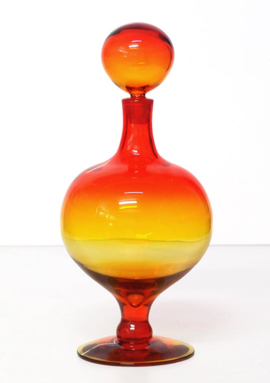 ___
(Items also available individually, please email to inquire.)

LEFT: round footed decanter with ball stopper, designed by Wayne Husted in 1962.
Design #6211 in Tangerine, pictured in the 1962 catalog.
Measures 15.25 inches tall x 7 inches