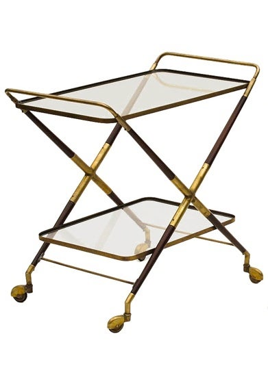 Light, airy form meets function in this elegant cocktail, bar cart of and mid century design by Carlo de Carli in 1955.  Striking to the eye and senses with brass handles, X shaped brass fittings, pivoting wheels and two levels of glass this cart is