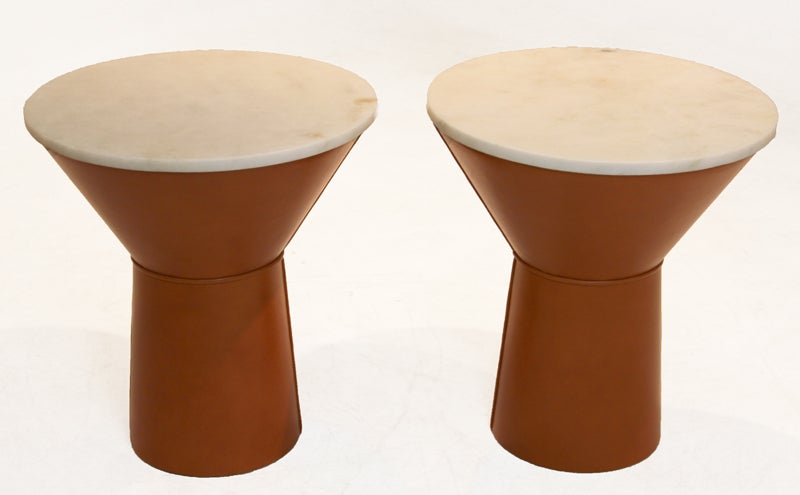 Conical leather side table or night stand with honed cream-colored travertine tops, so the surface is matte. The drum bases are upholstered in a thick caramel leather with double stitched seams and piping details.
Many pieces are stored in our