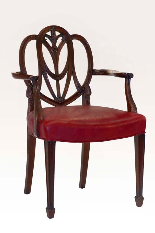 This stunning pair of heartback Hepplewhite mahogany chairs were created during the American Federal period, and popular throughout the eastern seaboard to the Carolinas from 1780 -1810. With its straight legs and spade feet, curvilinear shaped arms