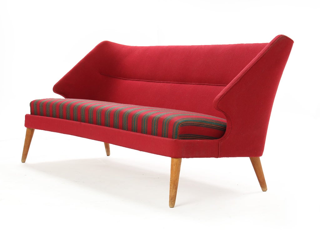 A red upholstered sofa on oak dowel legs known as 'The Flamingo' or 'Sofa 15'. Designed by Arne Wahl Iverson and manufactured by Hans Hansen, Denmark.