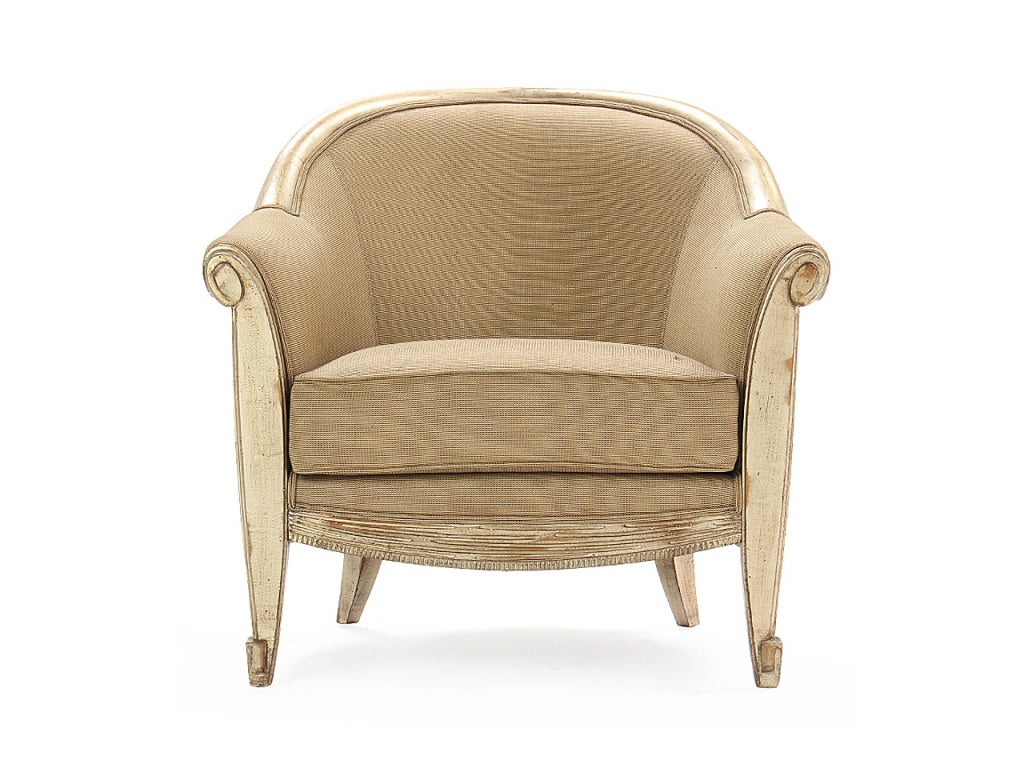 An armchair with a carved skirt and scroll arms with a faux nickel lacquer.