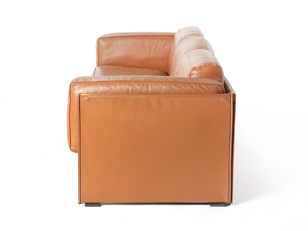 A brown leather 'Duc' three-seat sofa with exposed leather wrapped frame.