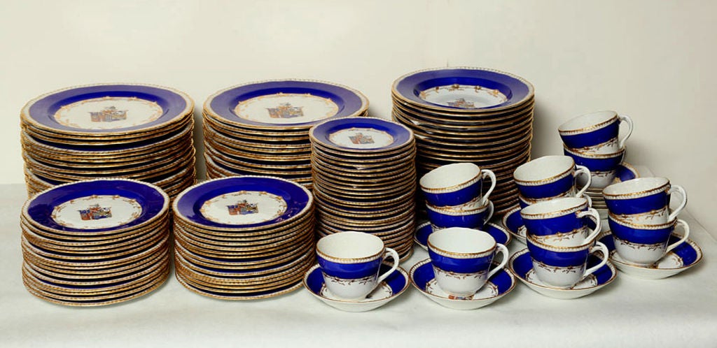 COMPRISED OF 37 DINNER, 16 SOUP, 23 BREAD & BUTTER, 30 DESSERT PLATES, 12 CUPS AND 12 SAUCERS, TOTAL 130 PIECES. THE PLATES AND SAUCERS CENTERED BY A COAT OF ARMS, WITH COBALT BLUE WIDE BORDER AND GILDED EDGE, THE CUPS WITH HANDLES MODELLED AS