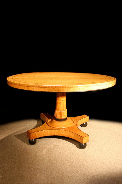 # S551 - Handsome Regency satinwood and kingwood crossbanded center table attributed to Gillow. The circular molded tilt top having rich kingwood crossbanding and ebony strung frieze, resting on a tapering column featuring a reeded and turned collar