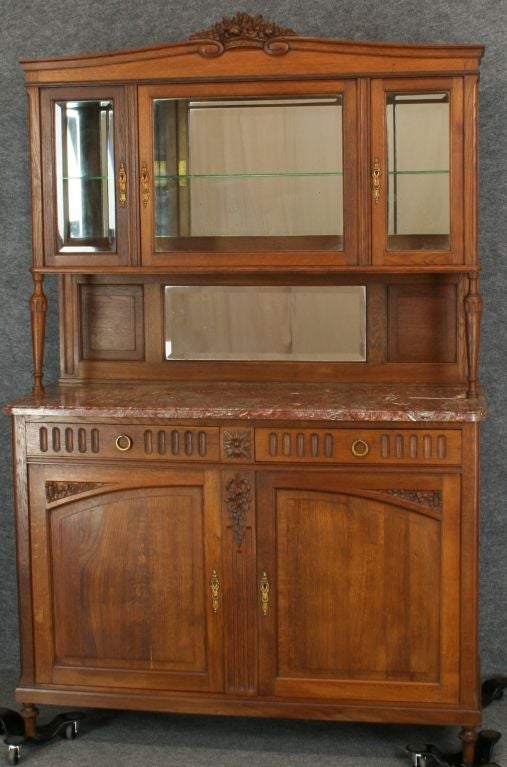 A French Country Louis XVI Style Buffet China Cabinet Hutch in oak with a marble top, beveled mirror and beveled glass doors in upper cabinet