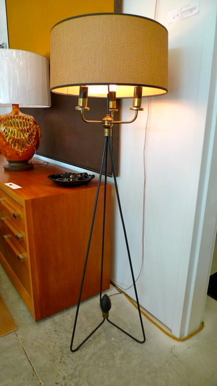 Early Gerald Thurston design for Lightolier.  Elegant iron tripod hairpin floor lamp with brass 3 light cluster and original barkcloth drum shade and original brass finial.  Large iron club shaped finial at center of hairpin base. Unusually fine