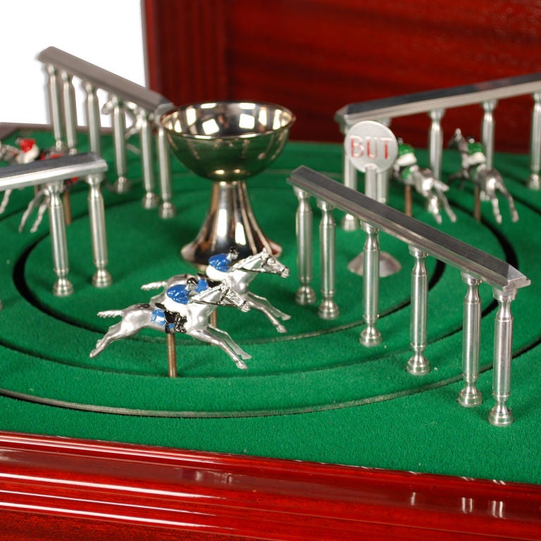 This is a large mechanical Horse Racing Game set in a handsome wood cabinet. The game is absolutely beautiful and is in excellent working condition. Turning the chrome handle crank starts the nine horses racing around the three tracks. There is a