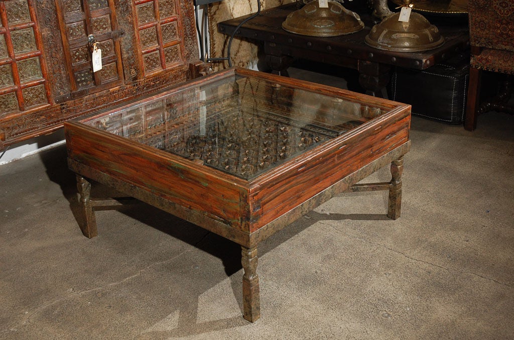 Very nice, carved architectural piece of window made into a coffee table and raised on custom iron stand, with a glass on top to protect the nice carving of flowers and geometric designs.<br />
<br />
Mosaik provides Antiques,Art Deco, Moorish
