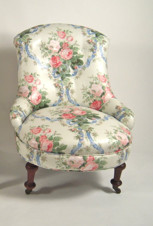 A 19th century slipper chair newly upholstered in a high quality polished cotton floral chintz, with walnut inverted tapering cylindrical legs in the front and splayed legs in the back.