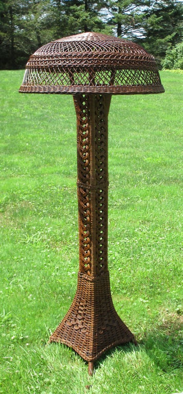 Natural stained wicker floor lamp referred to as the Eiffel Tower style for its square towering base resembling the Paris memorial.   Large scale, standing 70