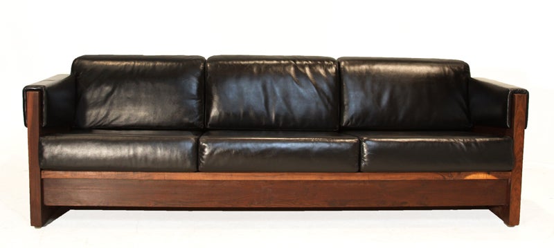 This sofa is composed of a Macaranduba wood frame with black leather cushions as well as leather wrapped arms. Note the chrome hardware.

Seat depth measures 21