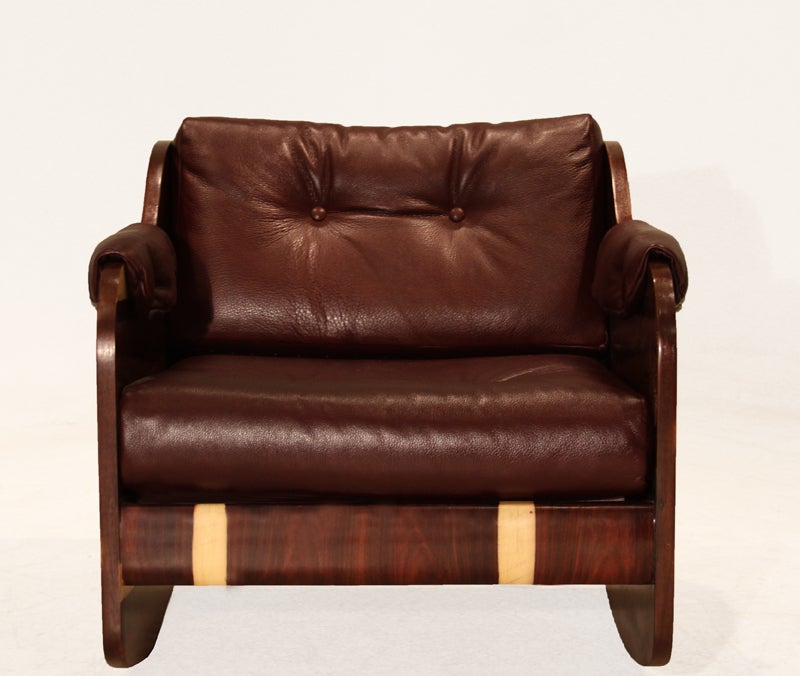 Rosewood and tufted leather rocking chair. The chair features dramatic sap grains, and the seat and armrests are upholstered in a deep burgundy leather.

Seat depth measures 21