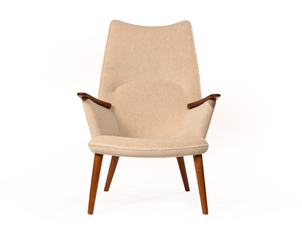 A high back armchair with teak arms and legs newly upholstered in cream wool Svak.

Actual chairs in image sold, others can be upholstered to match.