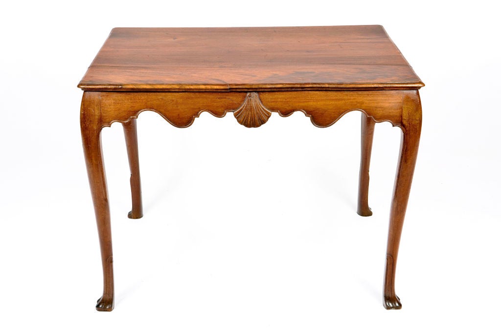 Georgian Irish mahogany center table with carved shell on frieze. Cabriole legs ending on trifid feet.