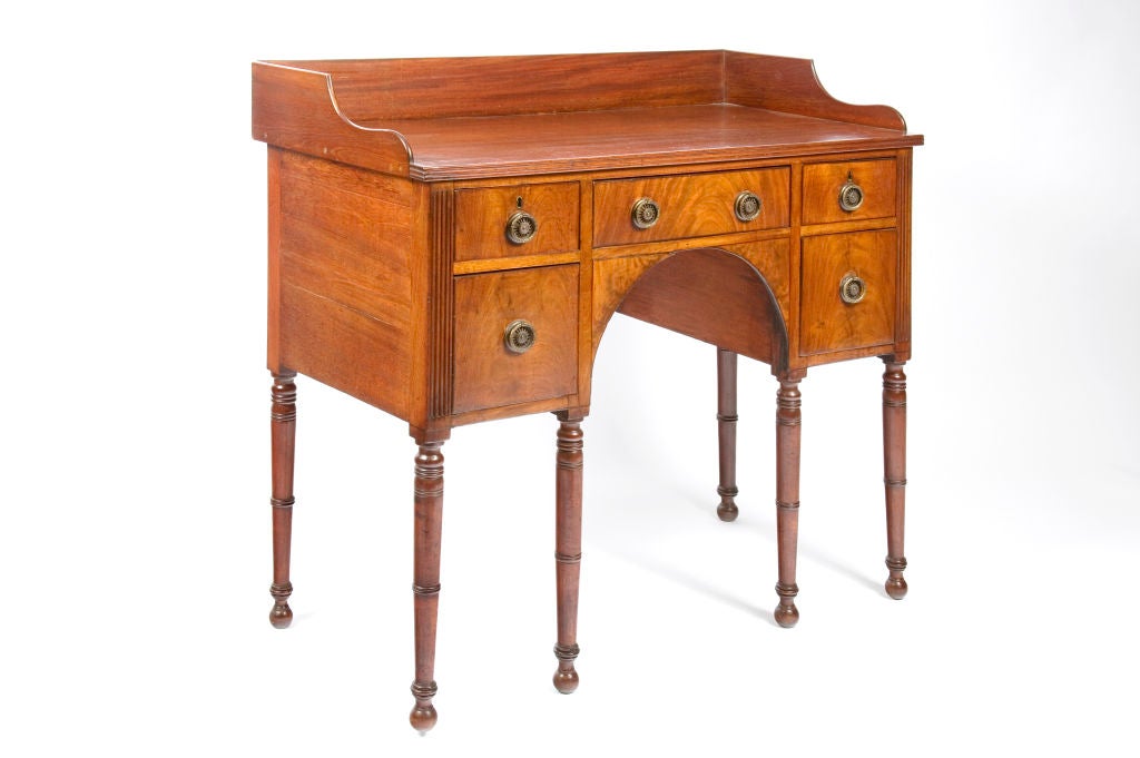Regency Mahogany Sideboard. With a shaped back plate, five drawers, turned legs, and original brass hardware.