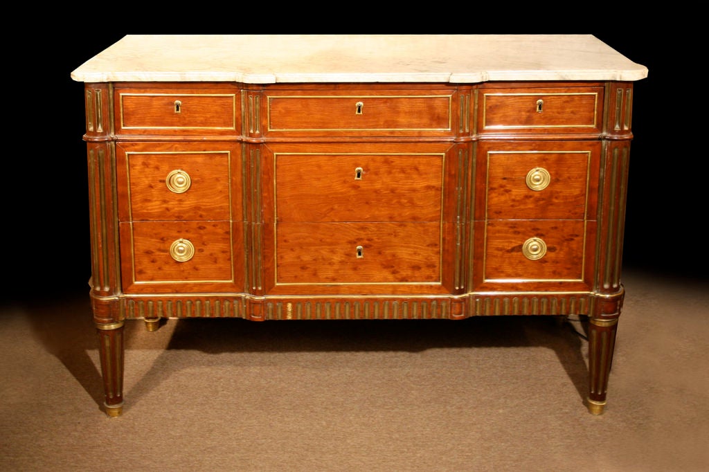 # P045 -  Elegant Louis XVI neoclassical commode enriched with brass mounts, and executed in plum pudding mahogany. Stamped by the maker, F. Bury. The breakfront form with a molded white mottled marble top. The frieze with three drawers above two