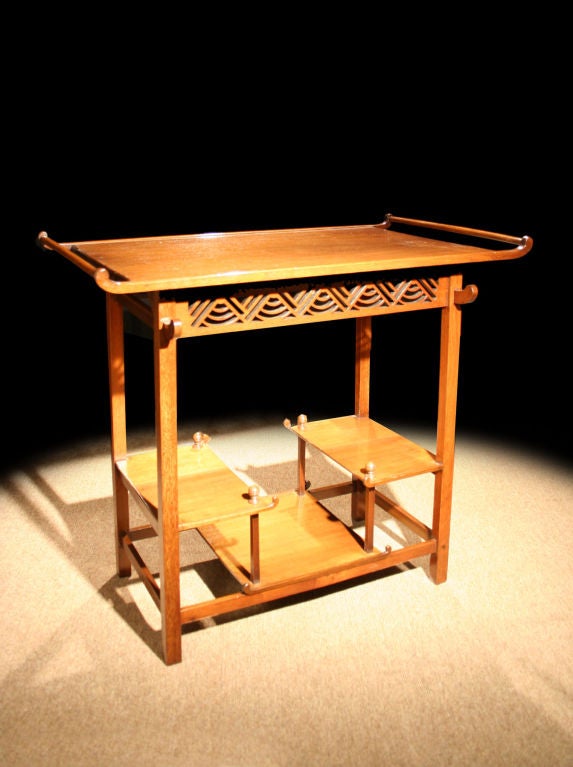 Heal and Son Anglo-Japanese inspired occasional table. The rectangular top flanked of nicely figured walnut above a pierced apron and three staggered shelves with carved ball detail. Japanese art and objects were a rich source of inspiration to many