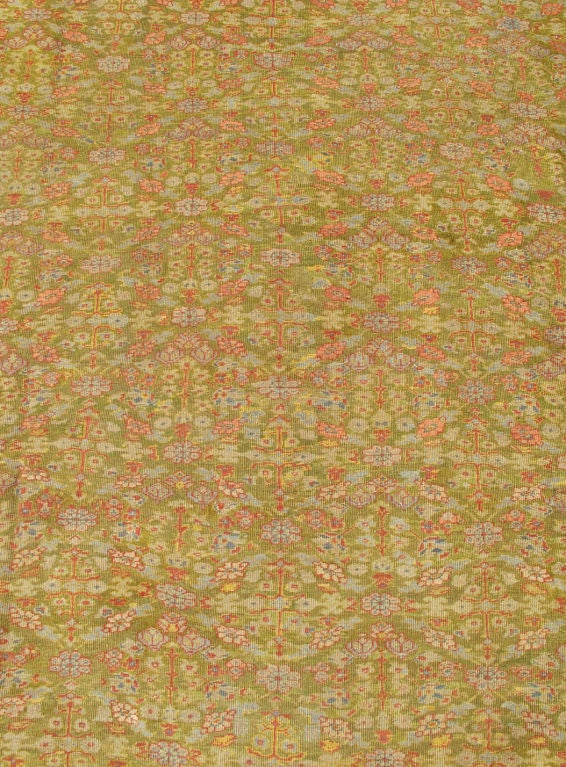 This exquisite antique Ziegler carpet beautifully illustrates the stunning Persian workmanship of the late 19th century. The intricately repeated floral patterns of soft yellows, lavenders, pinks and various shades of blue set upon a field of green