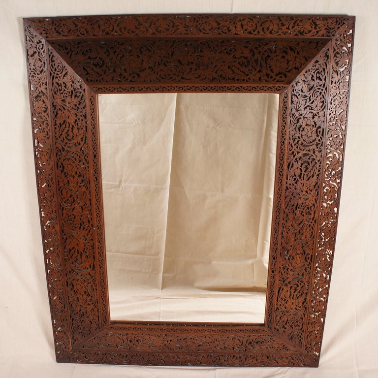 Lovely, ornate wooden mirror with intricate, foliage scrollwork detaling.