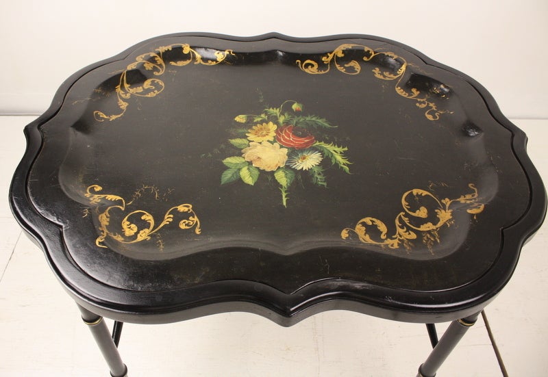 Oversized papier mache tray in original full-color paint, with some overpaint on the decorative gilded corners.  Important size makes this an above-the-norm tray.  New stand, black lacquer and gilt. Coffee table height.