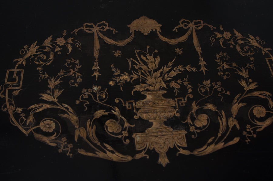 French Louis XVI Style ebonized desk with etched brass inlay and ormolu. Top edging in brass foliate ormolu and centered with floral and foliate- decorated brass inlay, resting on tapering , circular legs ending in toupie feet. Stretcher X base and