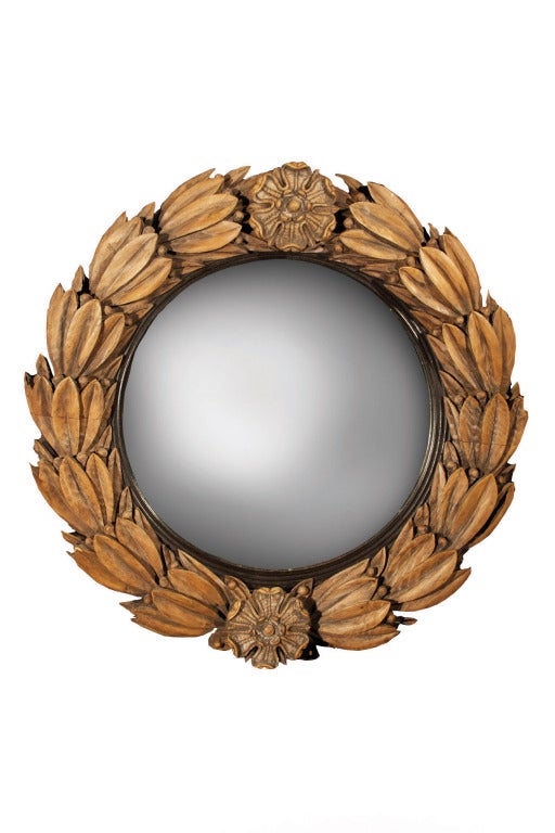 Carved pine laurel wreath convex mirror withTudor roses top and bottom and ebonized reeded inner slip. The bold scale of the leaves on a small size mirror has a decorative and playful style.<br />
English, 1830<br />
<br />
<br />
See similar