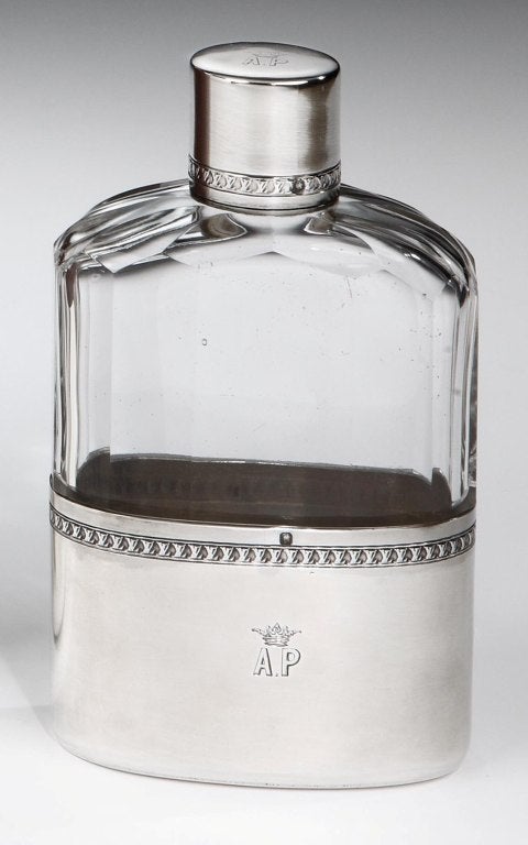 A stylish and heavy gauge Sterling silver and facetted glass hipflask, with screw cap featuring the LV Monogramme running around the cap and body, the lower half serving as a drinking cup. Engraved with the monogram 'AP' and crown motif to the cap
