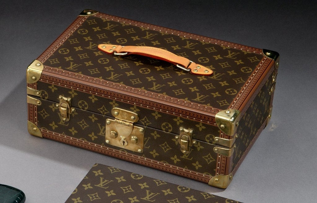 A ‘Monogramme’ patterned canvas covered cigar humidor by Vuitton Paris, with gilded brass locks and catches with leather top-handle and original key, the cedar-lined interior with modern hygrometer and humidifier, a lift-out top-tray with movable