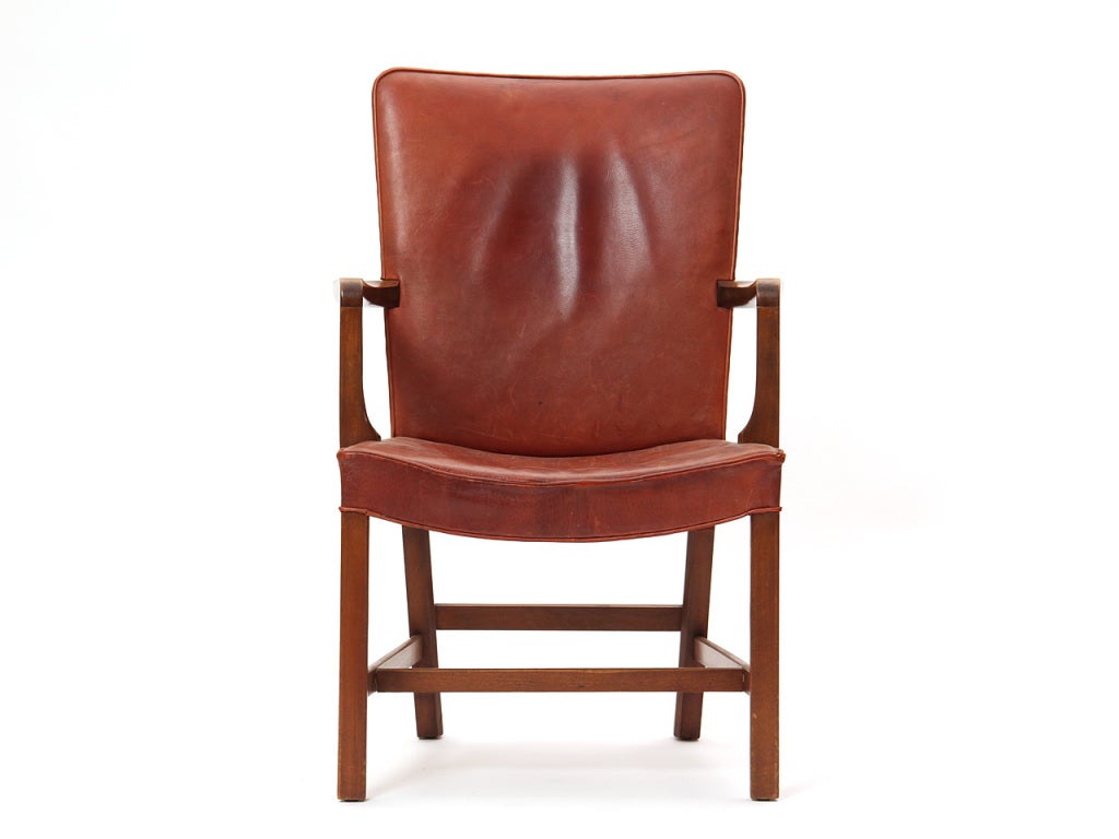 An elegant Scandinavian Modern armchair / side chair designed by Kaare Klint featuring Cuban mahogany and the original natural leather upholstery. Made in Denmark by Rud Rasmussen circa 1940s. Original Rud Rasmussen tag still attached underneath.