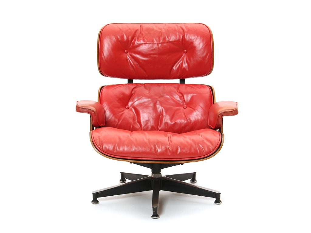 A swiveling lounge chair with a laminated highly figured rosewood shell, retaining its original custom-ordered red leather upholstery.